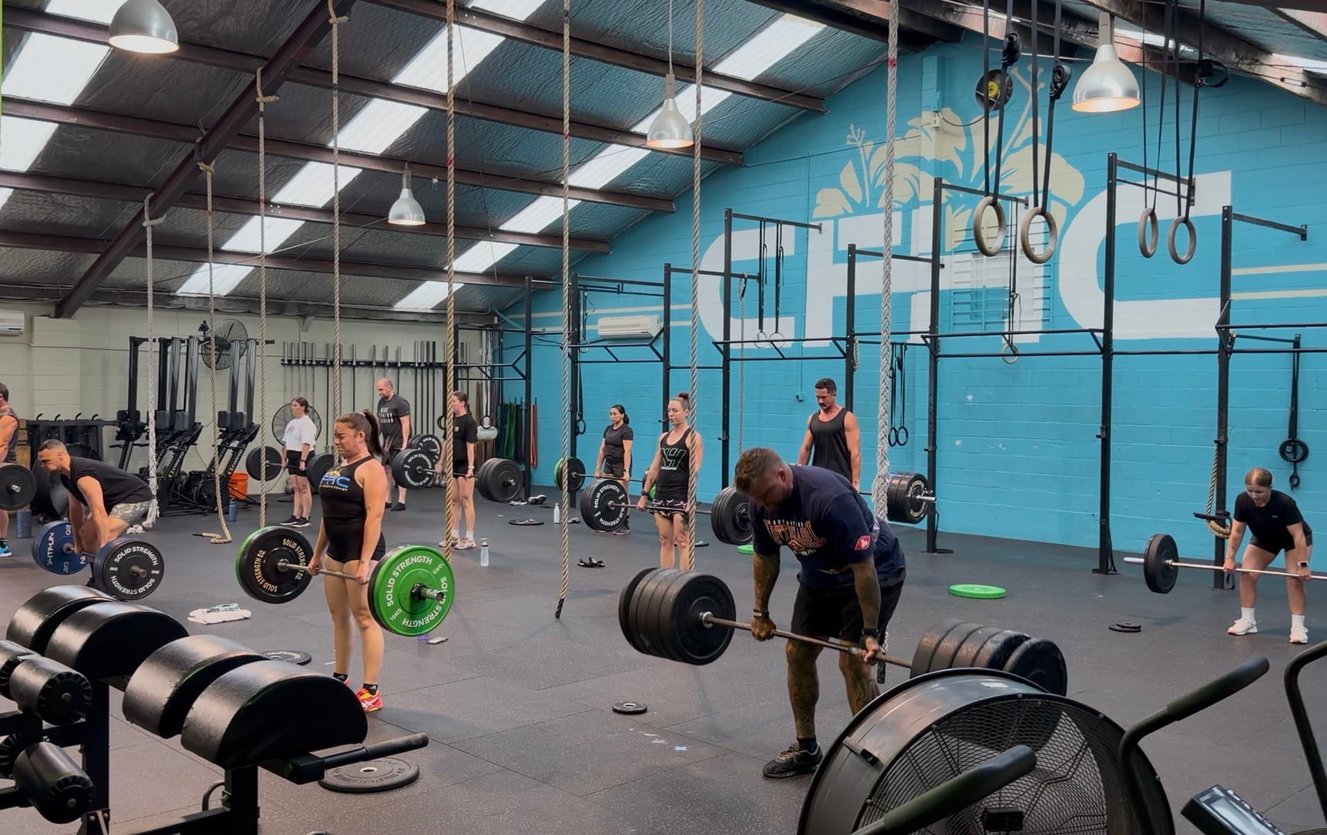 Members lifting barbells during a coached group class at CrossFit Hibiscus Coast